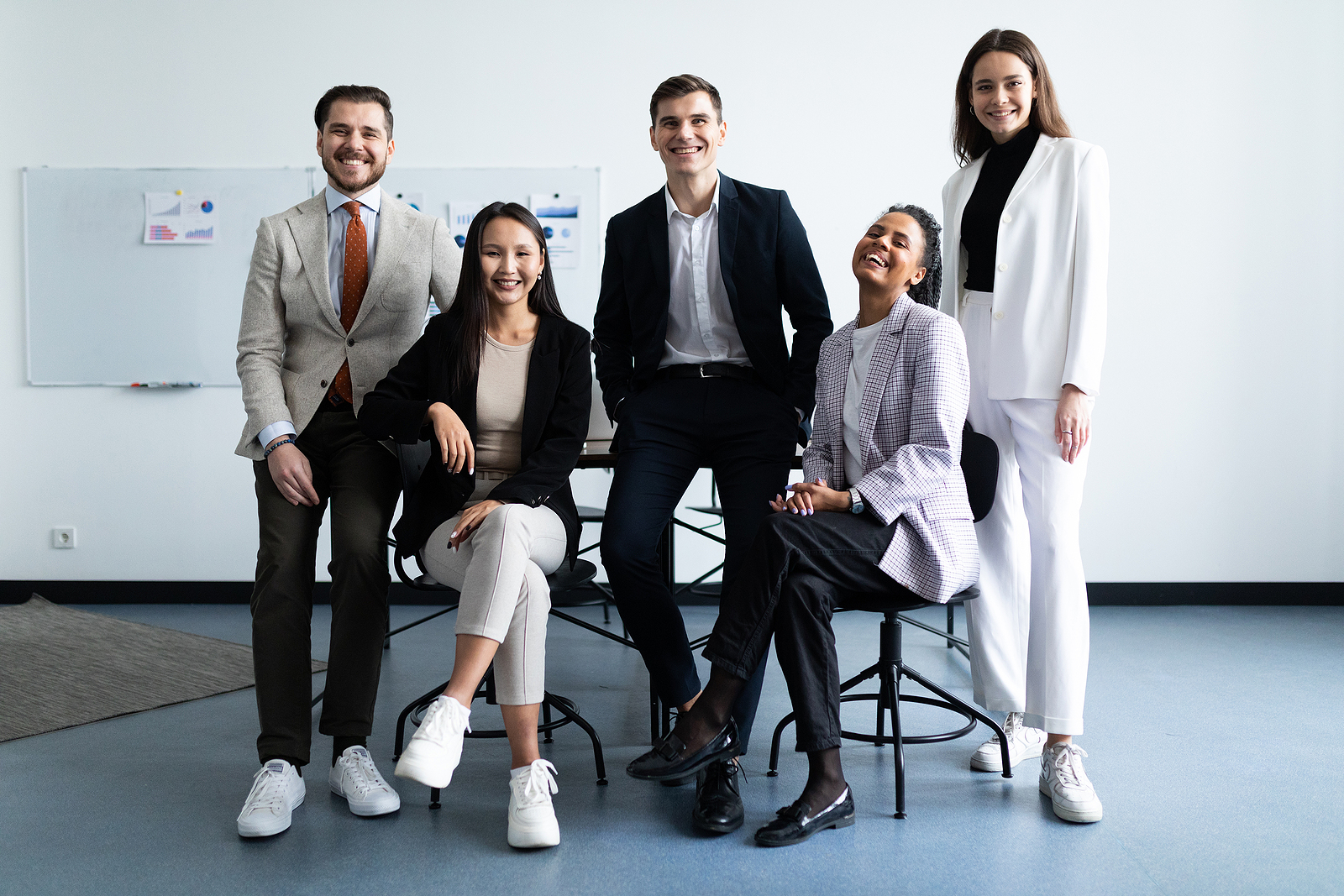 Diverse group of professionals standing together in office, showcasing PEO provider by industry expertise and tailored HR solutions.