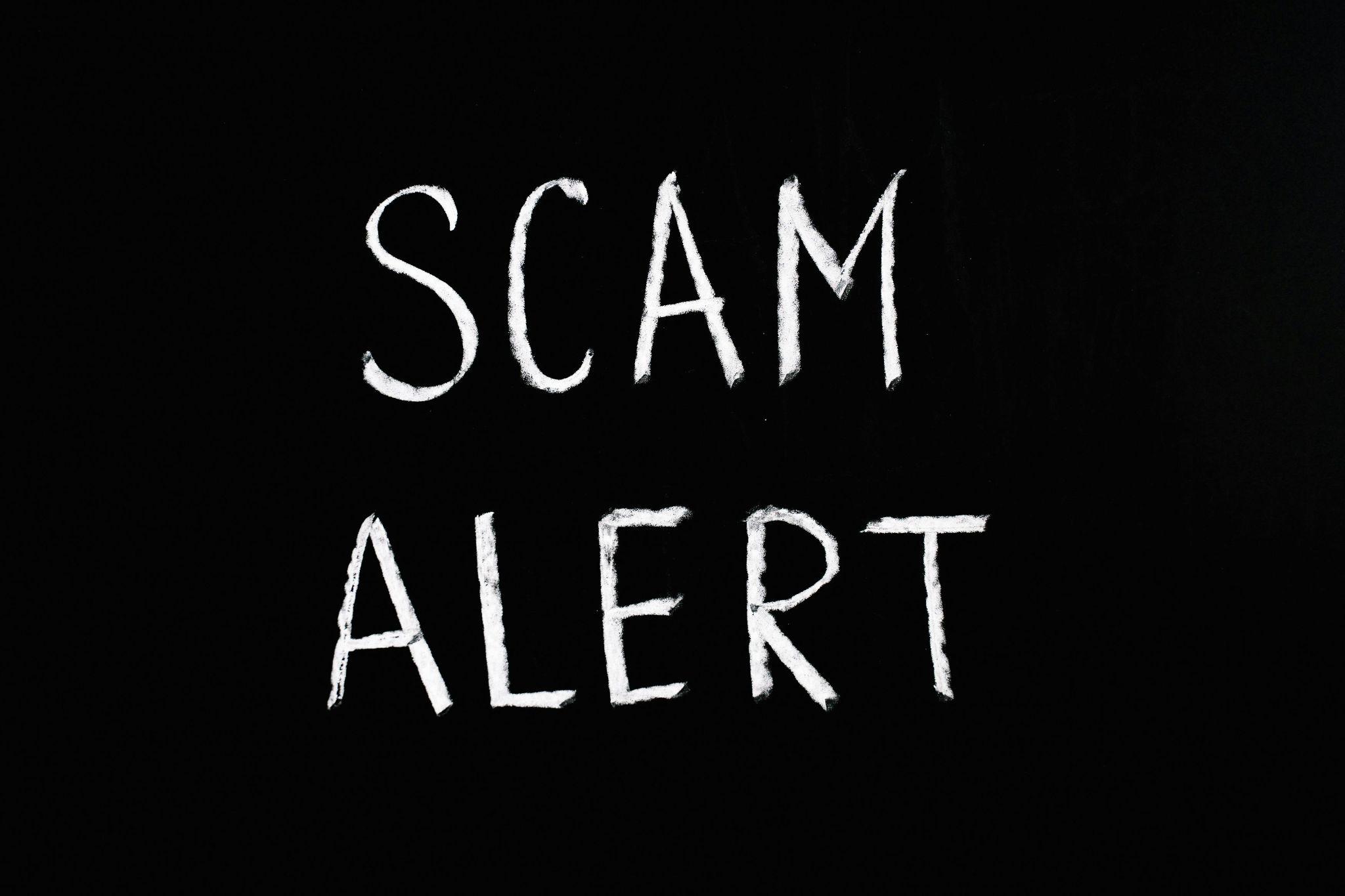 Scam alert written in chalk on a blackboard highlighting phishing scam warnings for HR departments